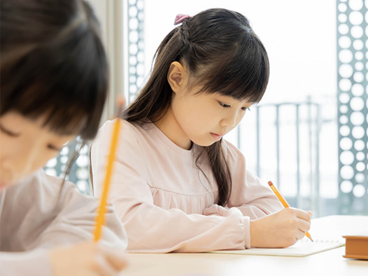 室内で学習に取り組む女の子の写真。